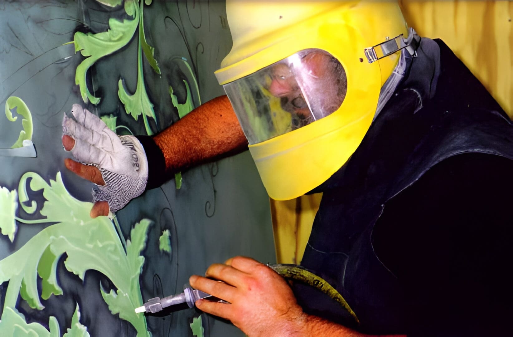 A person in a yellow helmet is painting