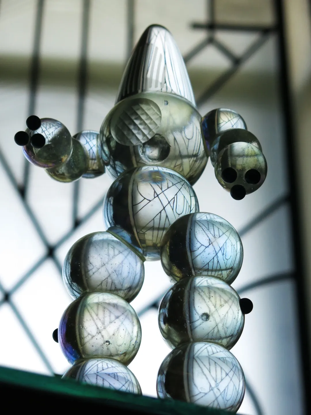 A glass sculpture of a person with many balls.