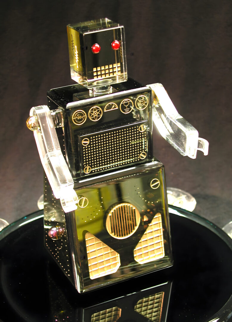 A vintage-style, shiny metallic toy robot with red eyes and clear plastic arms displayed against a dark background.