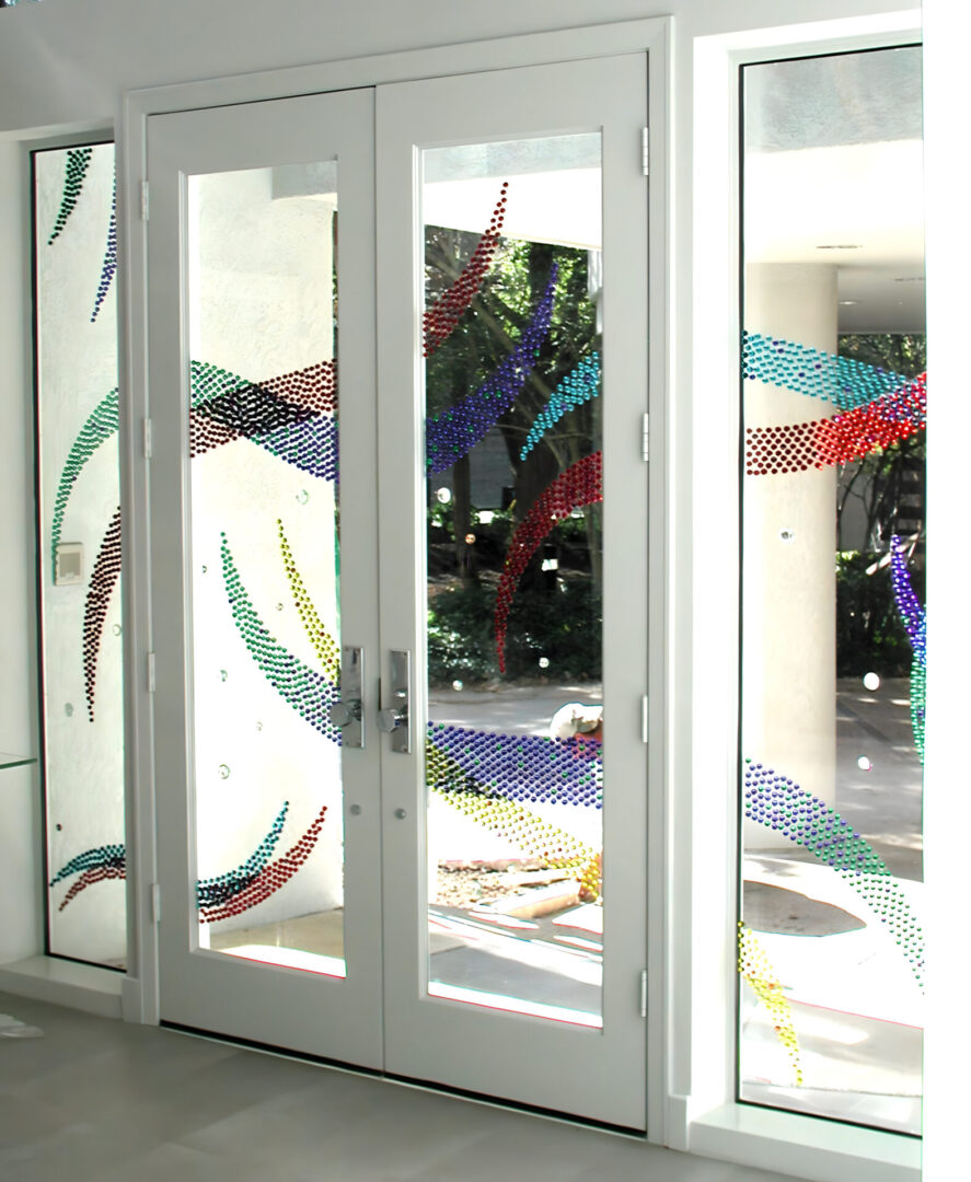 Glass doors with colorful dot patterns creating wave-like designs.