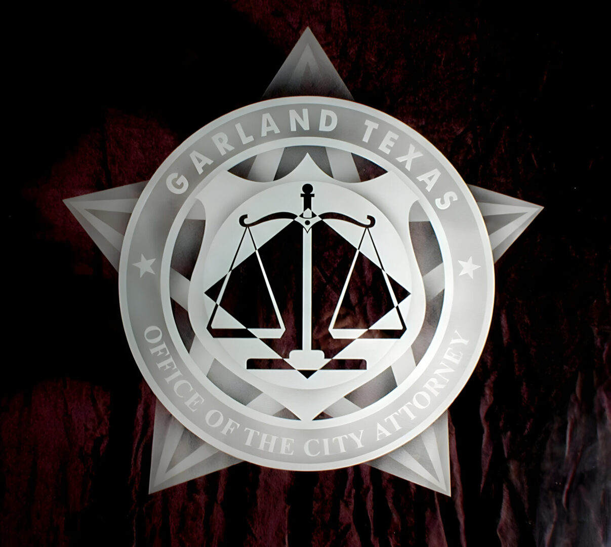 Emblem of the garland texas office of the city attorney with a scale symbol at the center.
