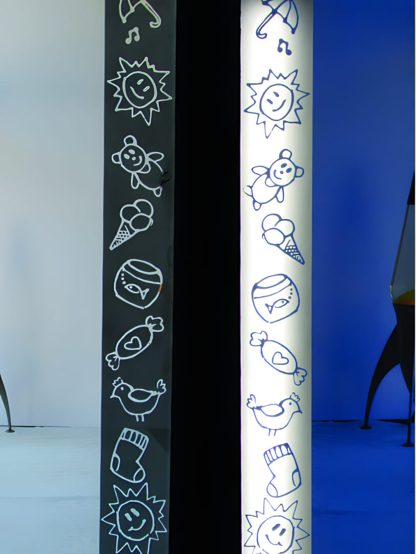 Two vertical banners displaying various simplistic, monochromatic icon designs, one with a dark background and the other light, in a room with blue walls and part of a person visible on the right.