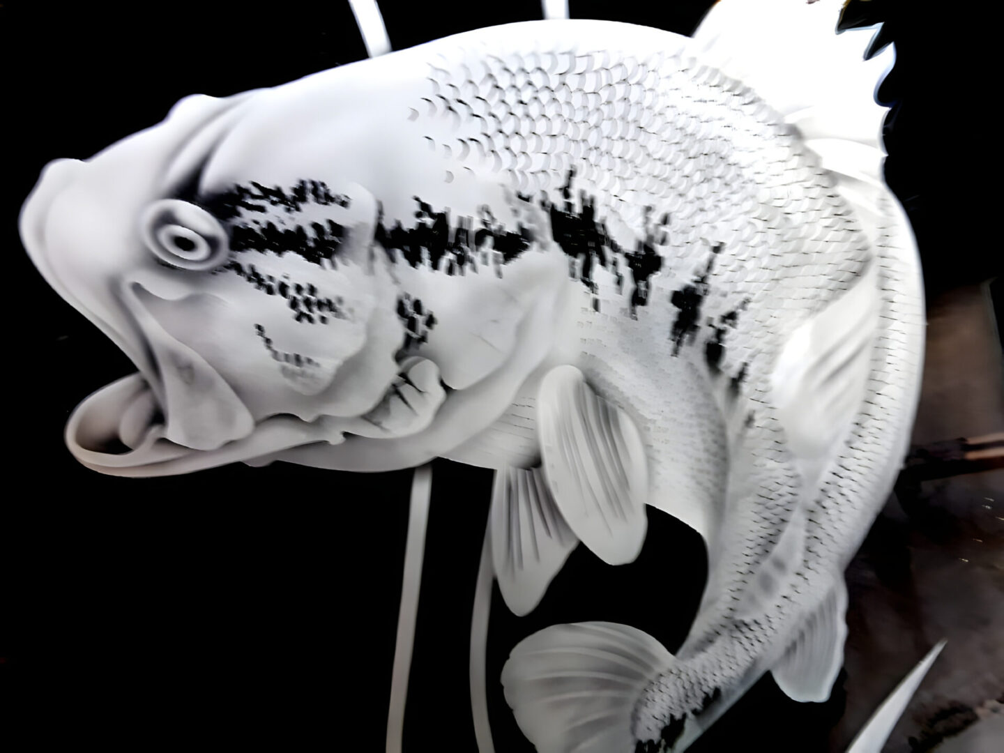 A close-up of a white and black koi fish sculpture with intricate scales and fins.