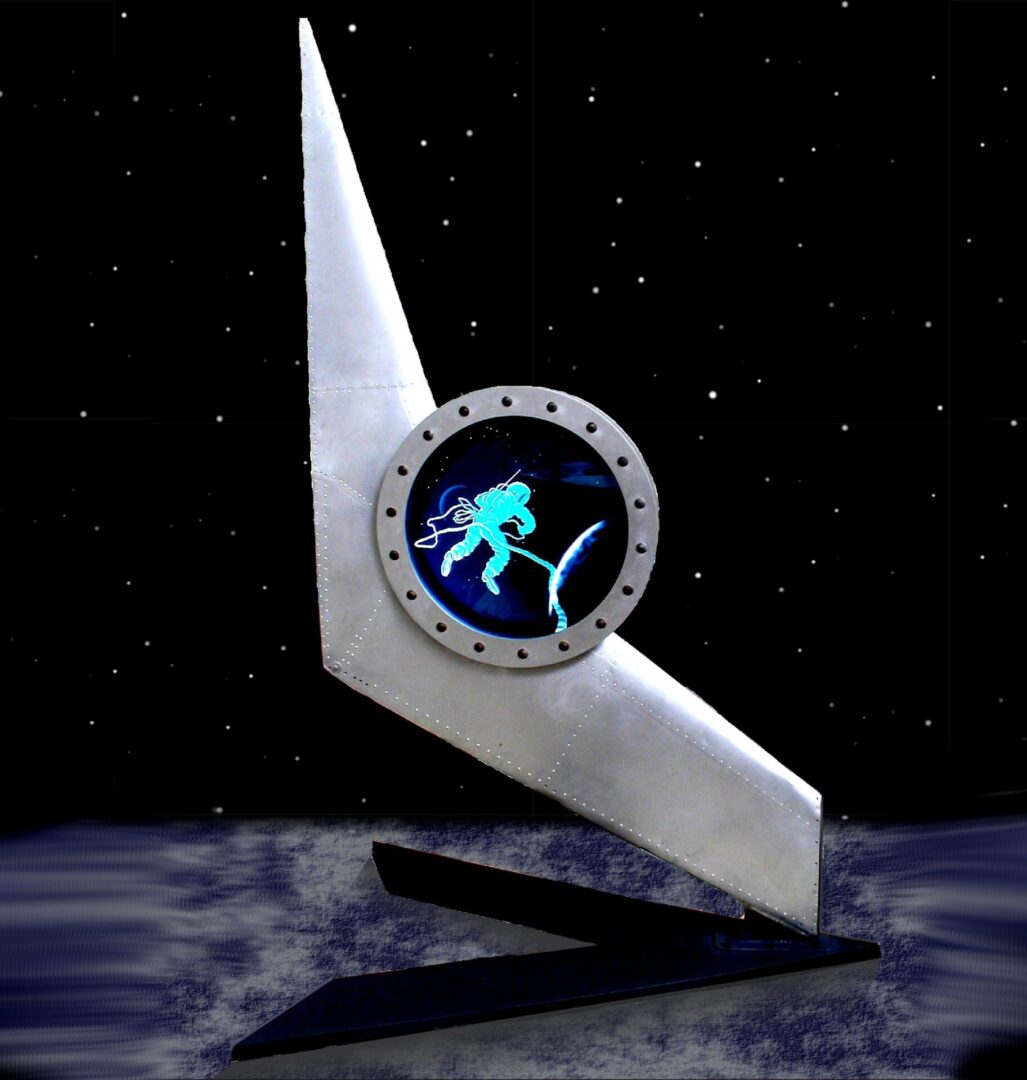 A monument featuring an astronaut depicted inside a circular window, set against a starry background.