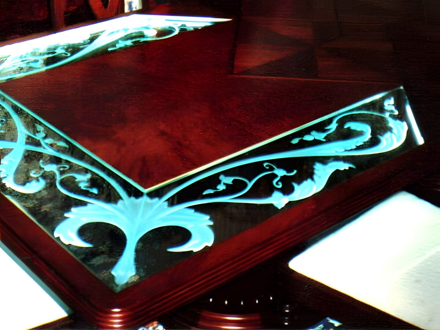 Ornately carved wooden table corner with reflective glass surface and distinct reflections.