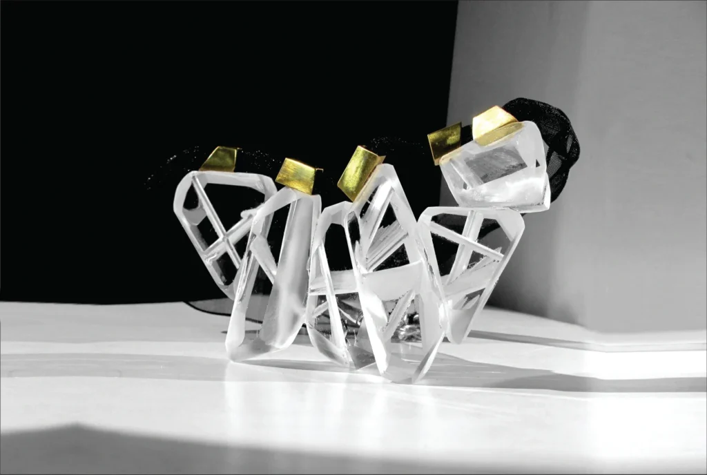 Geometrically designed bracelet with clear gem accents on a reflective surface.