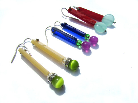 Three sets of colorful pen-shaped earrings displayed against a white background.