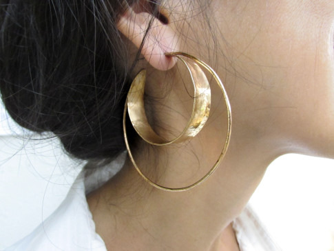 A close-up of a person wearing large hoop earrings.