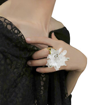 A person wearing a black lace garment holding a white crystalline mineral specimen.