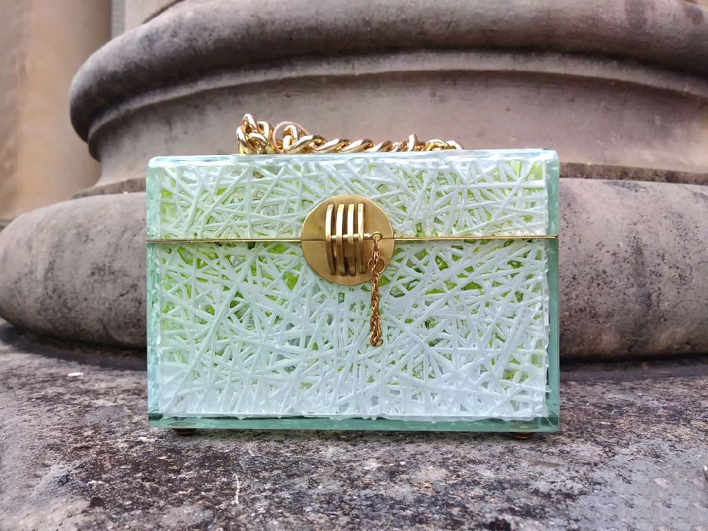 A green purse sitting on top of the ground.