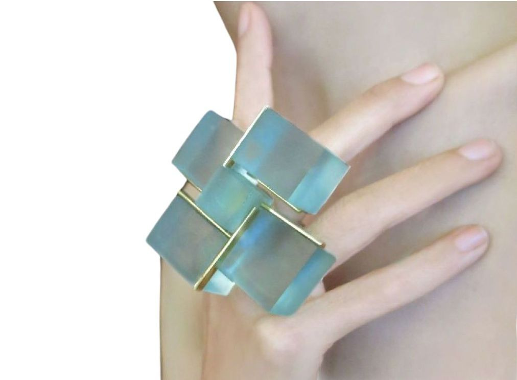 A woman wearing a ring with four squares on it.