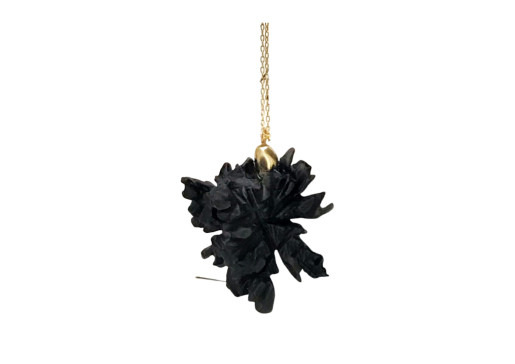 Black oak leaf pendant on a gold chain against a white background.
