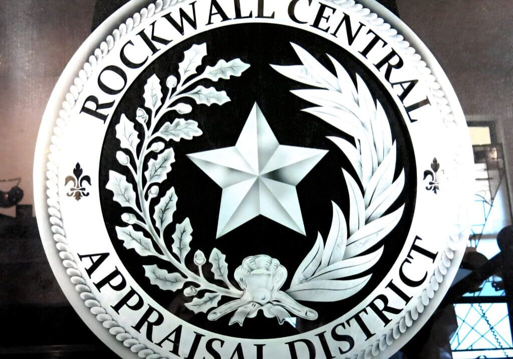 Emblem of rockwall central appraisal district featuring a prominent star and decorative elements.
